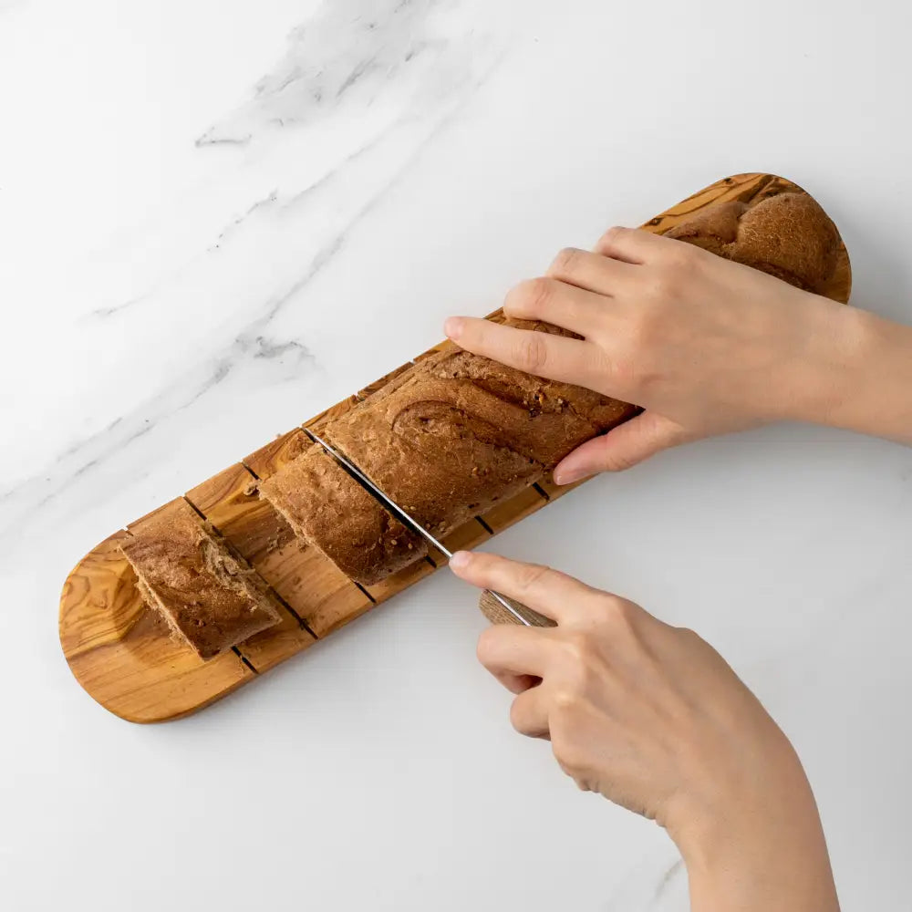 Sliced baguette på oliventre skjærefjøl for god matopplevelse